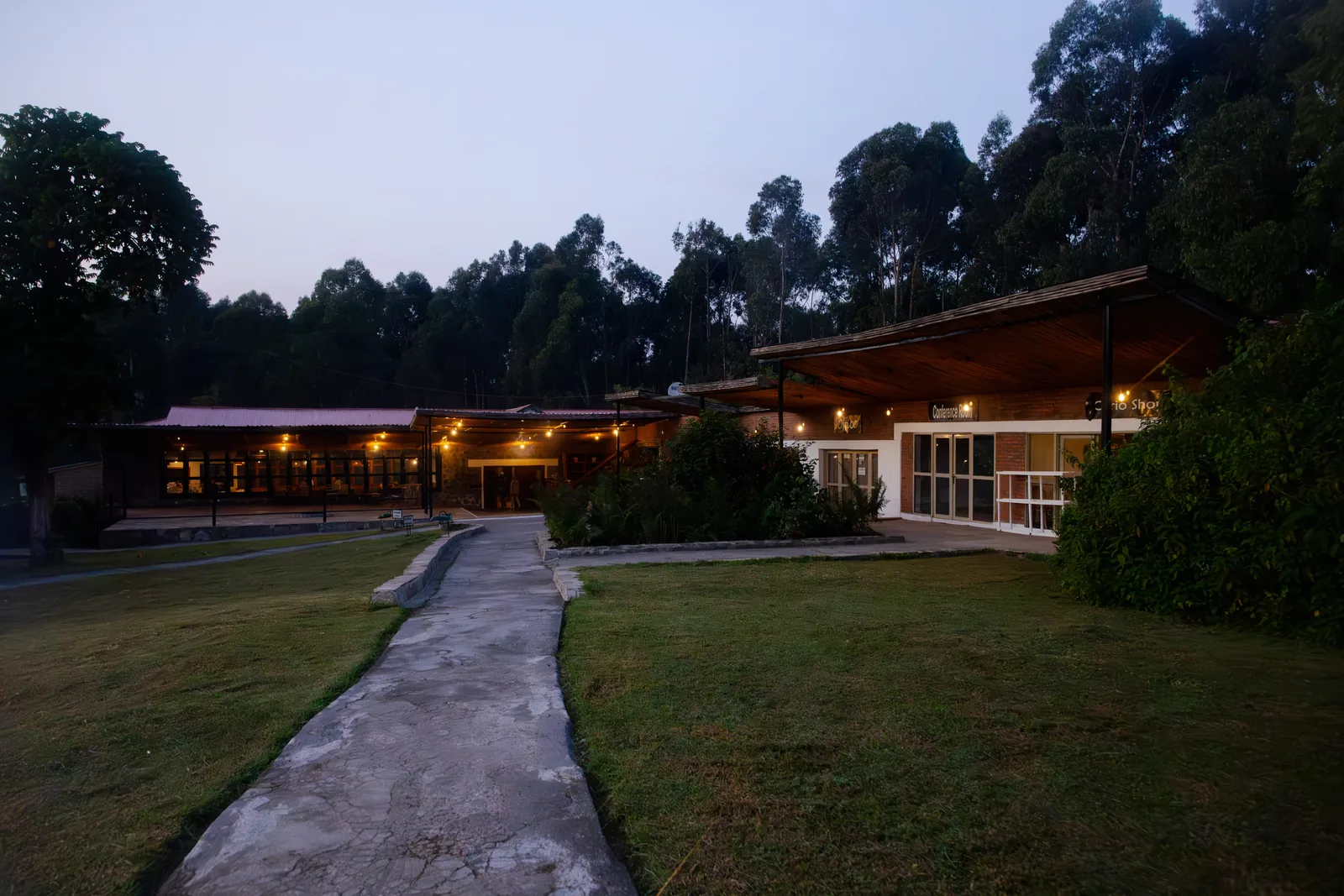 Mountain lodge buildings at dusk with warm interior light and pathway
